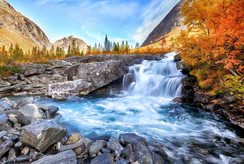 Beautiful autumn landscape with yellow trees and waterfall